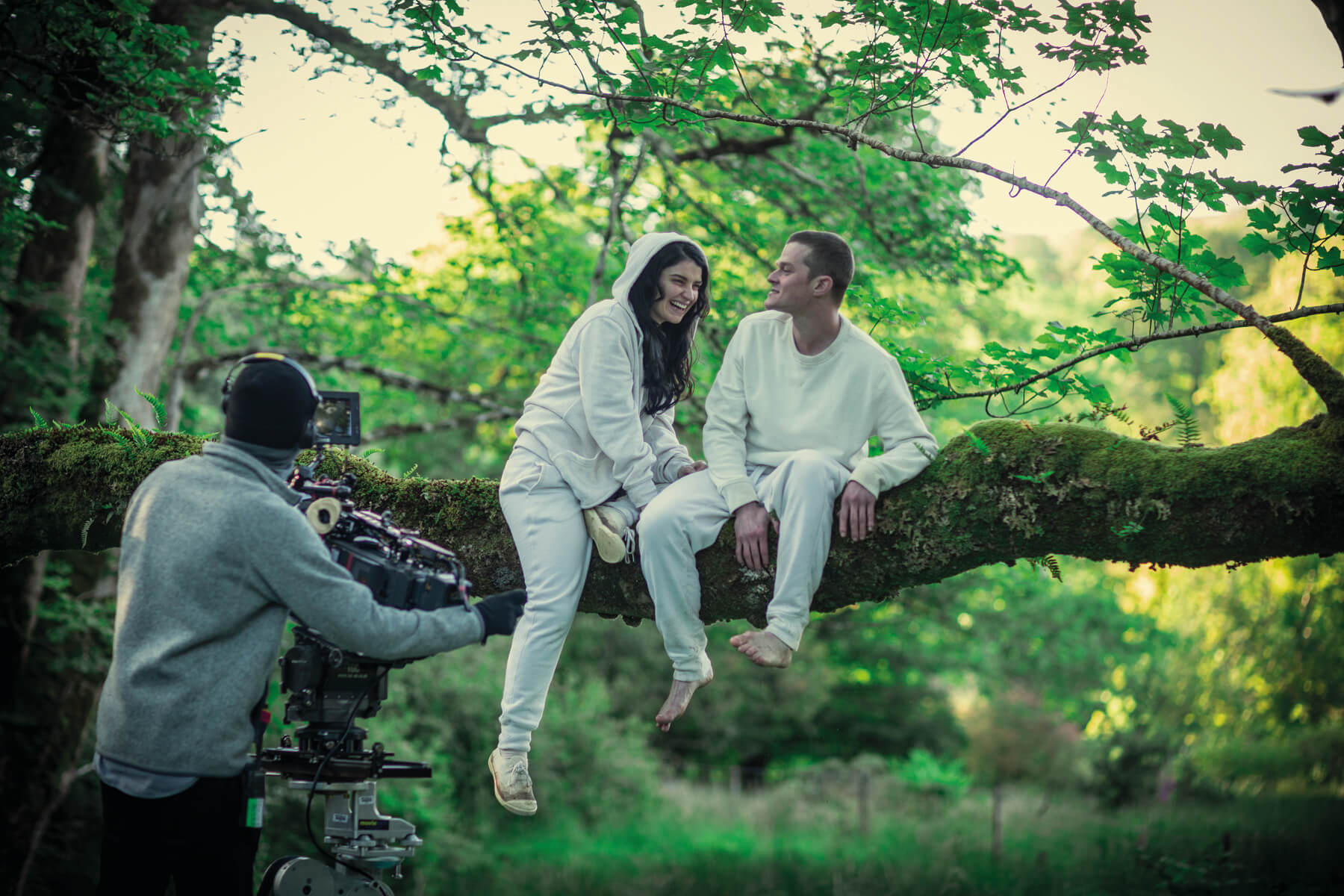 Eve Hewson and Robert Aramayo sit in a tree behind the scenes of Behind Her Eyes