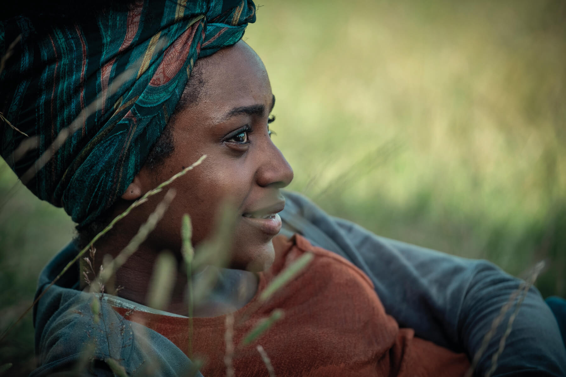 Simona Brown laying in a field as Louise during a scene from Behind Her Eyes