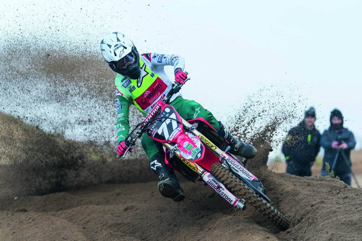 Motocross rider kicking up dirt through corner