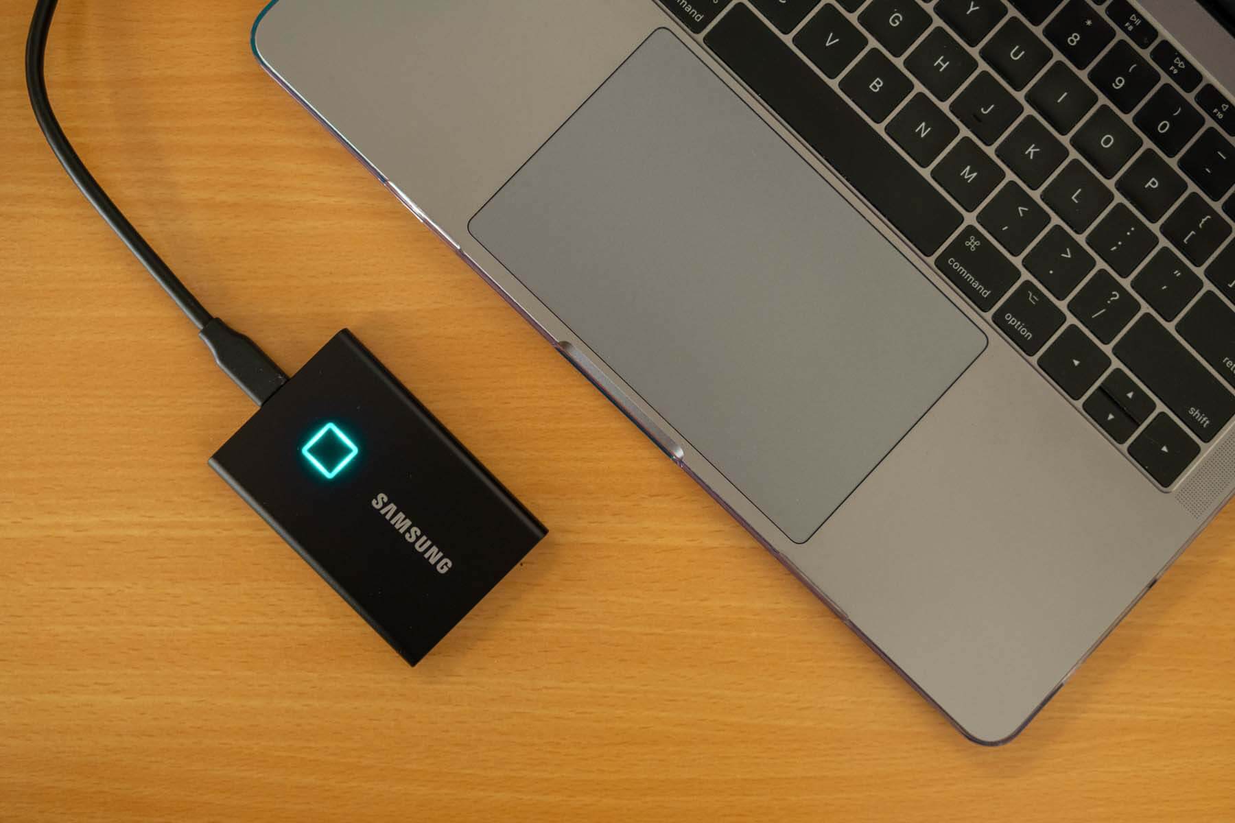 Samsung Portable SSD T7 Touch on desk next to laptop