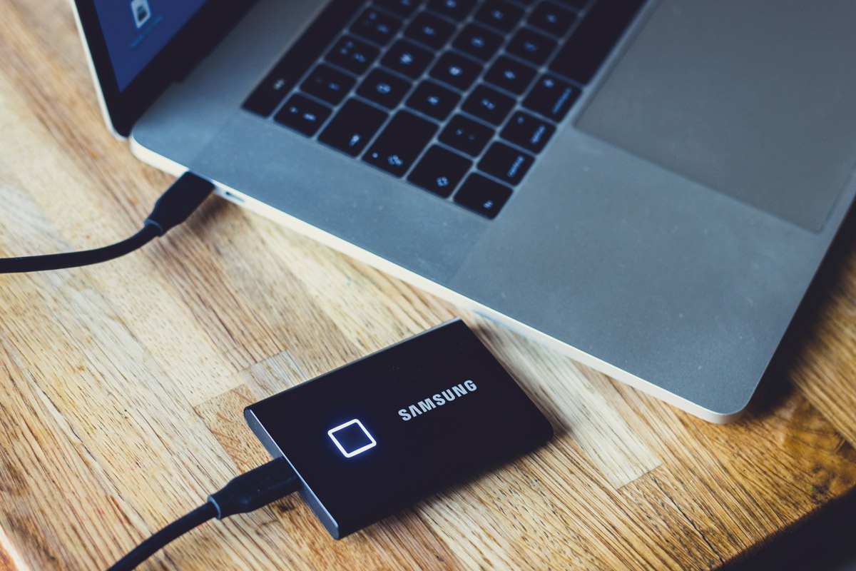 Samsung Portable SSD T7 Touch next to laptop on editing desk