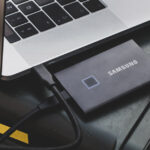 Samsung Portable SSD T7 Touch next to laptop on camera hard case