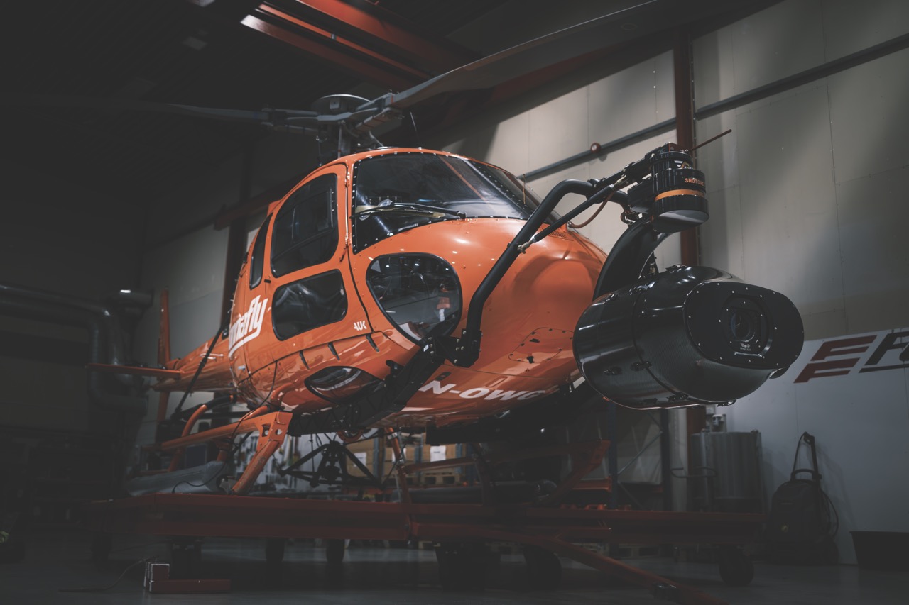 An orange helicopter in a hangar