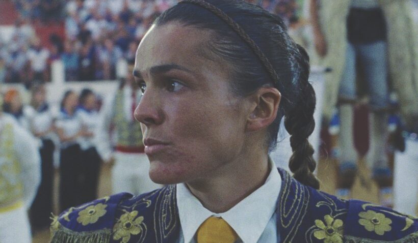 A woman standing in front of a crowd in a yellow tie