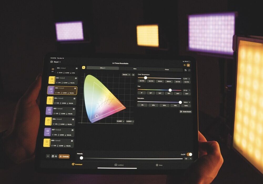 A tablet showing a colour app in front of yellow and purple panel LED lights