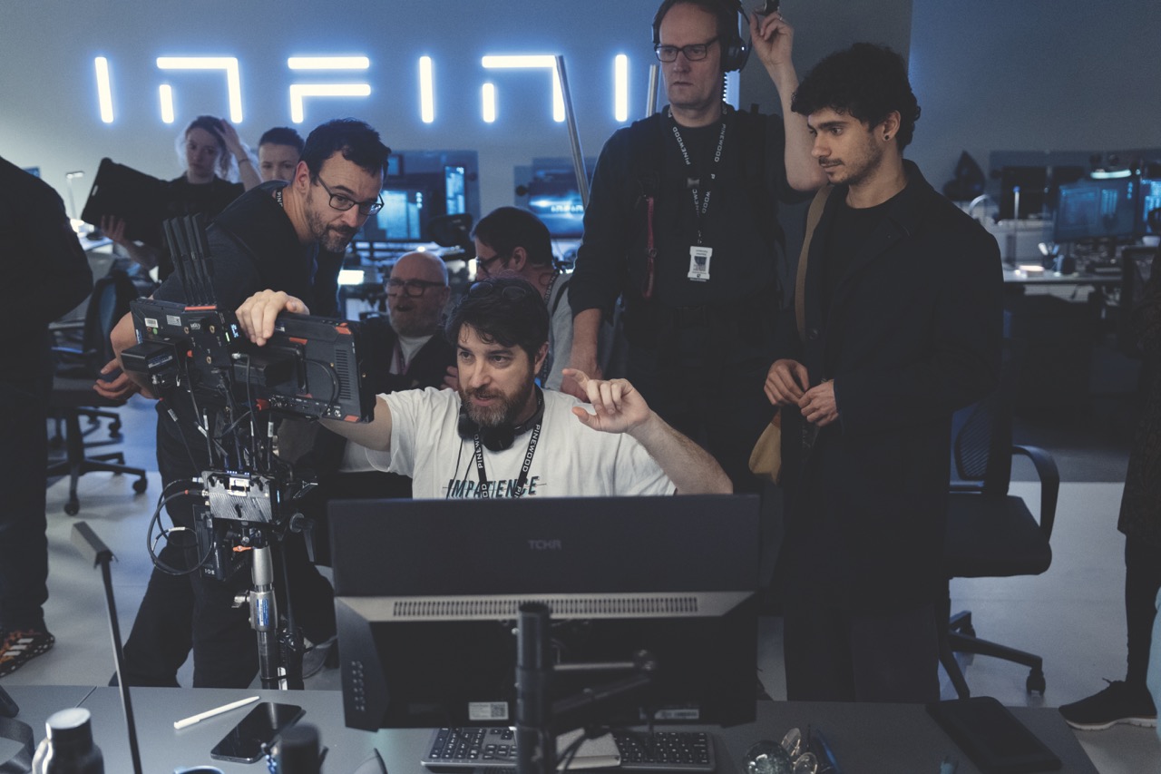 A filmmaking crew looking at a monitor and camera in modern filmset