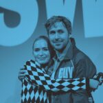 A woman hugs a man onstage. There is a blue overlay on the photo