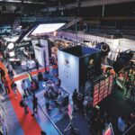 A top view of a conference hall filled with technology and stalls