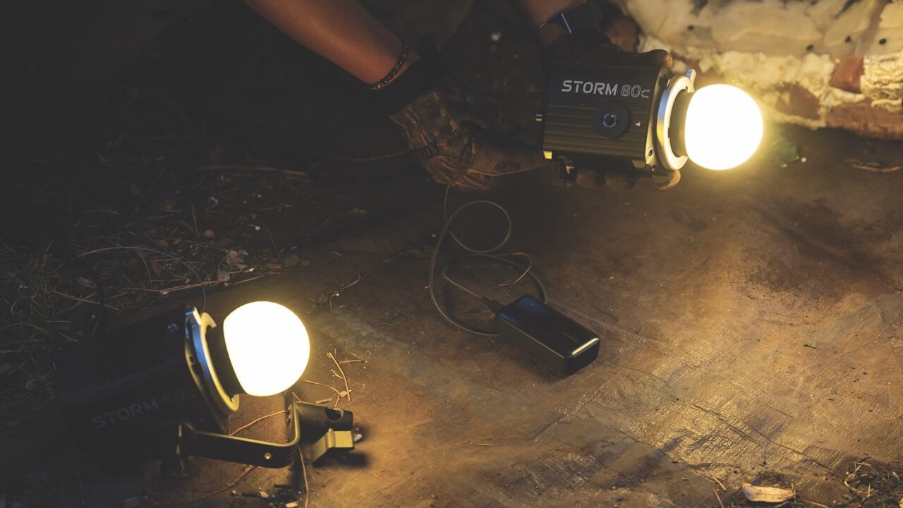 Two lighting devices set up on the ground in a cave