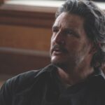 A man with long hair and facial hair looking concerned