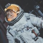 A man in a space suit floating in a sci-fi setting