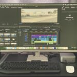 A monitor showing an editing software. A keyboard, mouse, speaker and Samsung SSD sit in front of the monitor