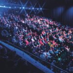 A large audience sitting on tiered seating in a large auditorium