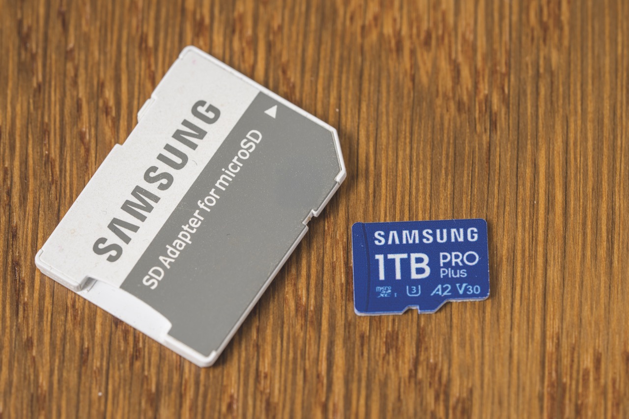 A blue and a white Samsung SD card laying at angles on a wooden surface