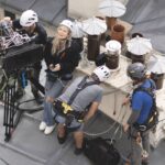 A team standing on a roof with filming equipment