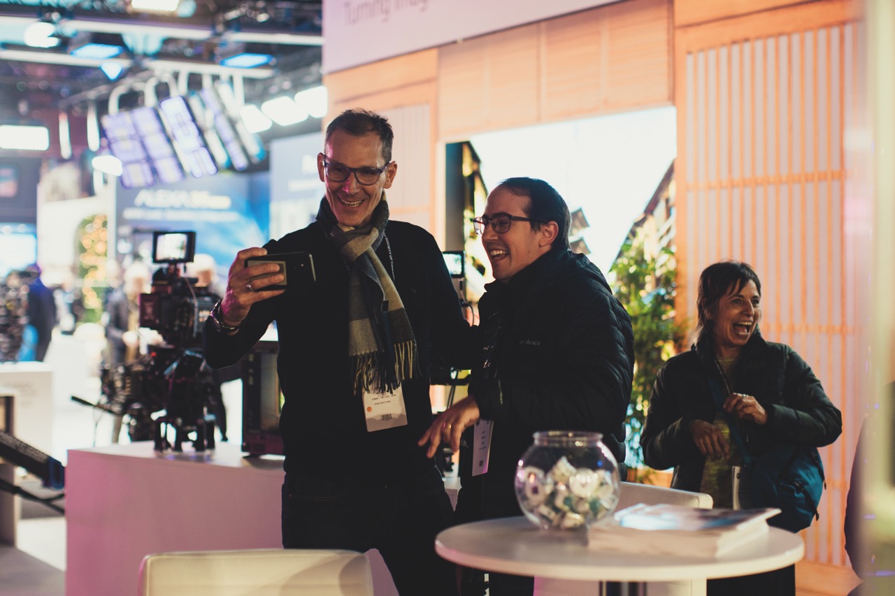 A group taking a selfie around a table at a conference