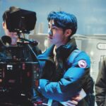 A group looking at a professional camera at a conference