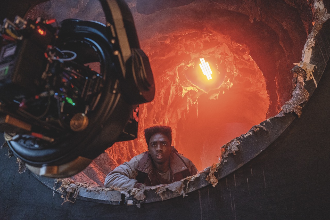 Boundaries were pushed in camera, like the red lighting effect in the Upside Down An actor on a sci-fi film set with a bright orange light behind and a professional camera in front