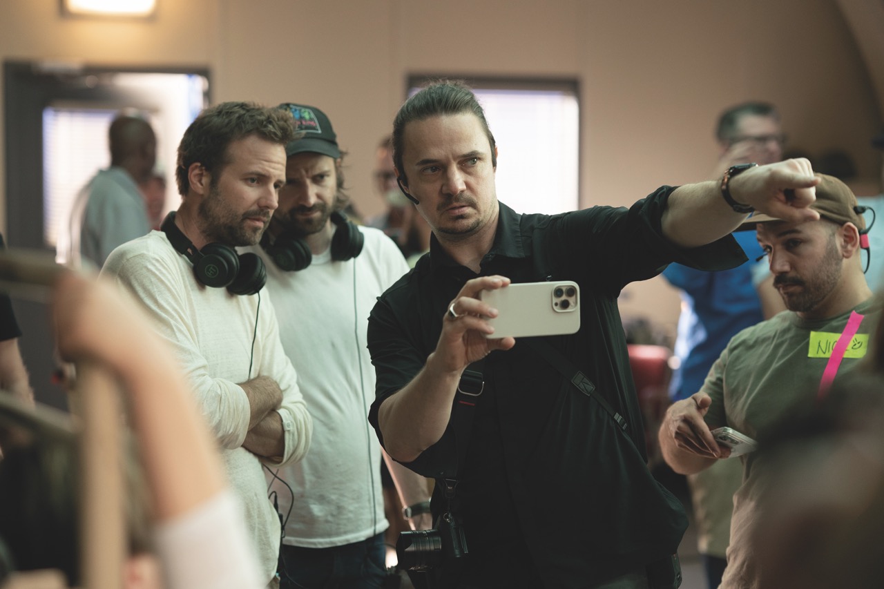 Boundaries were pushed in camera, like the red lighting effect in the Upside Down A film team taking direction from a man holding a smartphone in landscape